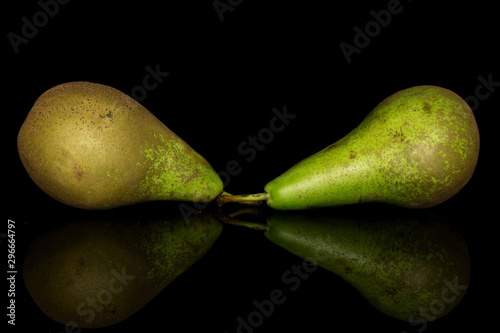 Group of two whole fresh green pear isolated on black glass photo