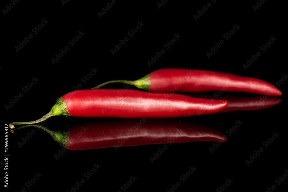 Group of two whole hot red chili cayenne isolated on black glass