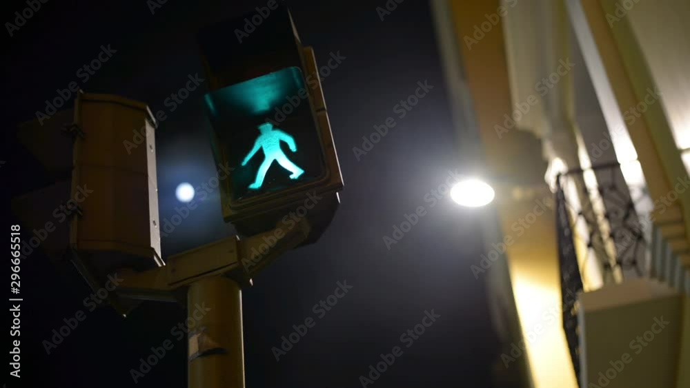 Toma noctura de un semáforo peatonal y al fondo la luna