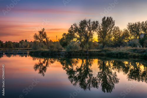 sunset over the lake with reflection of trees
