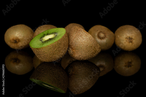 Group of five whole two halves of exotic brown kiwi isolated on black glass