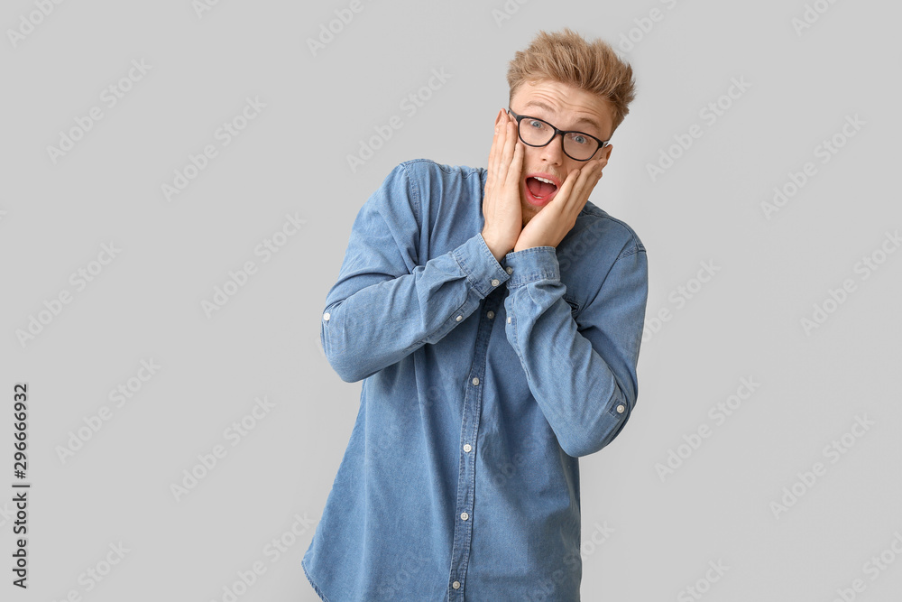 Shocked young man on light background