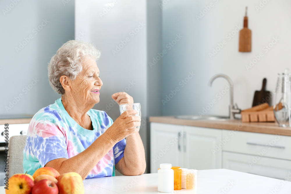 Elderly woman taking medicine at home Elderly woman taking medicine at home