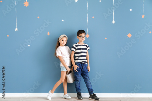 Cute fashionable children near color wall