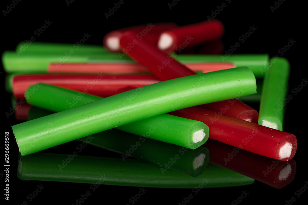 Lot of whole sweet stick candy isolated on black glass Lot of whole sweet stick candy isolated on black glass