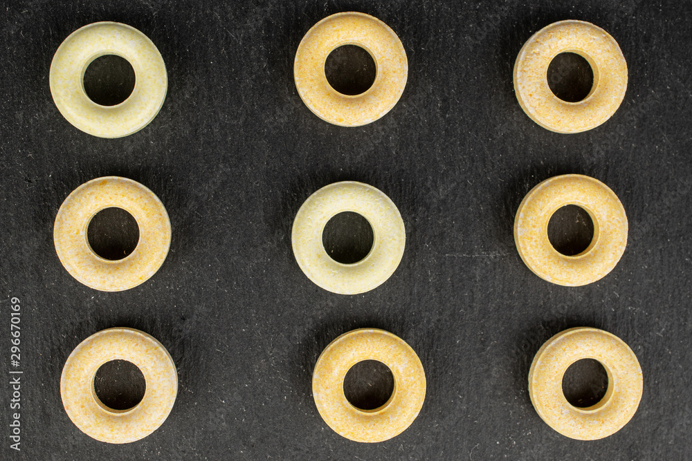 Fototapeta premium Group of nine whole round pale yellow candy flatlay on grey stone