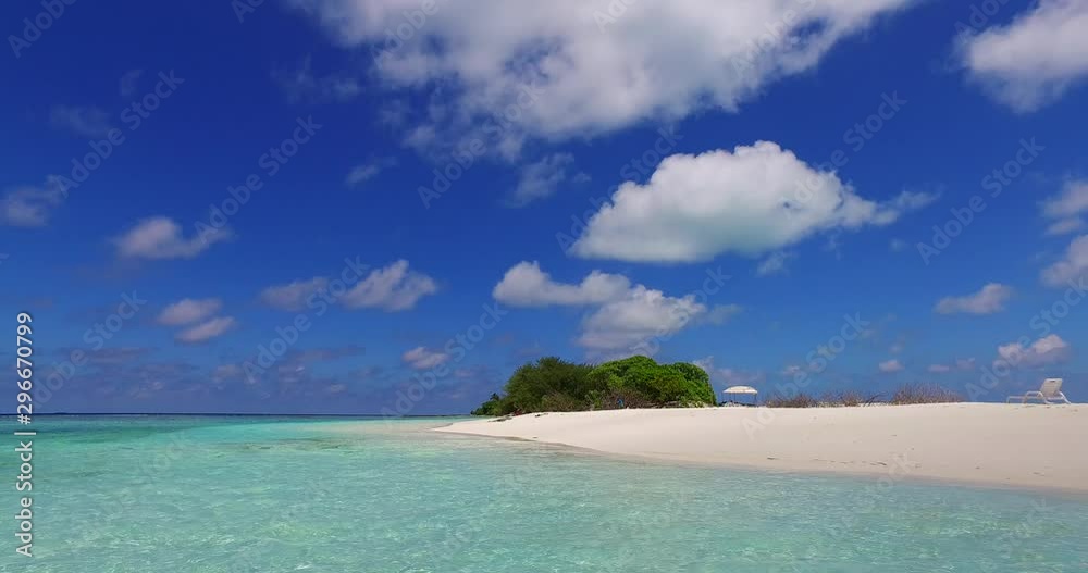 A view of clear tropical water transitions to look up towards the end of the island and a blue sky with fluffy clouds in the Caribbean A view of clear tropical water transitions to look up towards the end of the island and a blue sky with fluffy clouds in the Caribbean