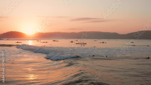 Sunrise at the surf spots of Gerupuk in Lombok, with a view on the bay with the fishing boats and surfers. Aerial shot. photo