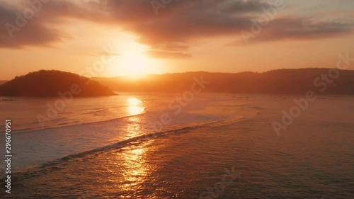 Sunrise at the surf spots of Gerupuk in Lombok, with a view on the bay with the fishing boats and surfers. Aerial shot. photo