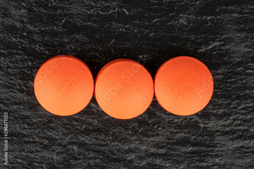 Group of three whole orange tablet pharmacy flatlay on grey stone photo