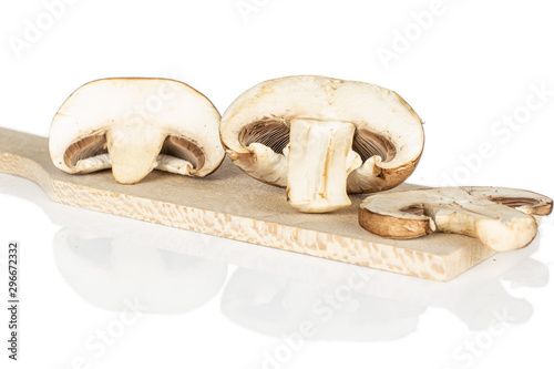 Group of two halves one slice of fresh brown mushroom champignon on wooden cutting board isolated on white background