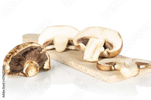 Group of one whole two halves one slice of fresh brown mushroom champignon on wooden cutting board isolated on white background
