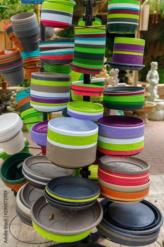 Multicolored plates for decorative pots on the shelves in the greenhouse