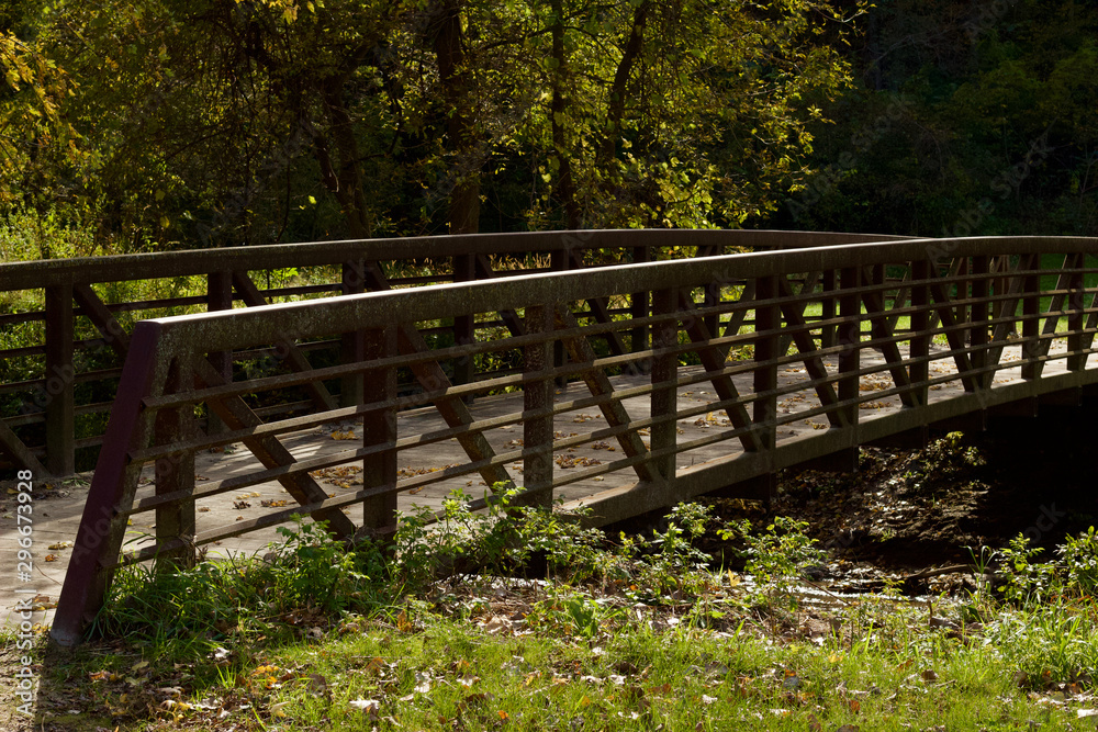 Landscape view of a rustic bridge over a river in a woodland natural public park area Landscape view of a rustic bridge over a river in a woodland natural public park area