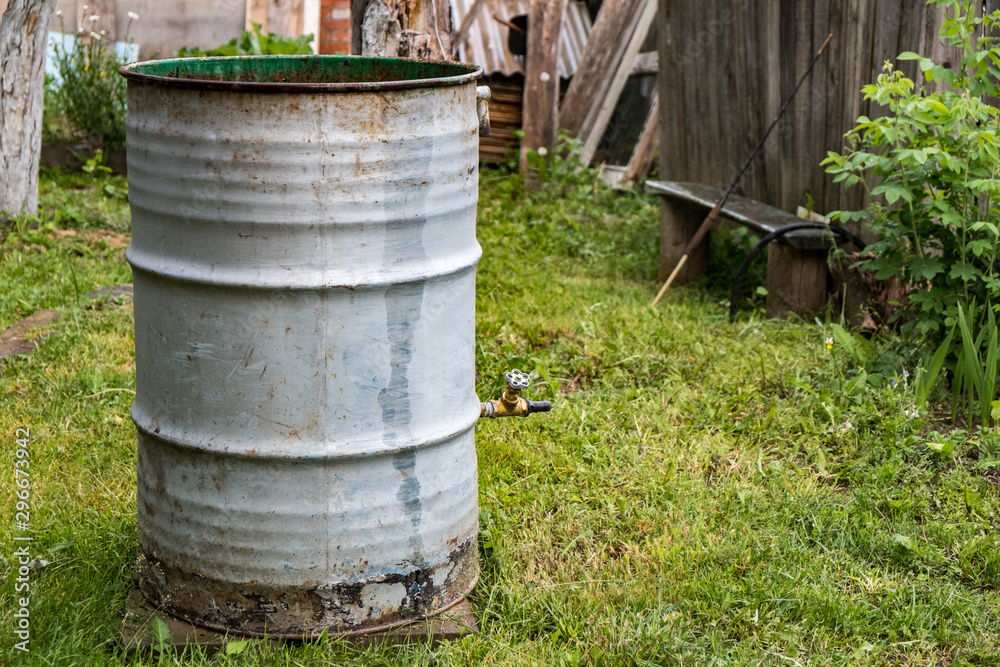 Old rusty barrels with rain water. Water butt Old rusty barrels with rain water. Water butt