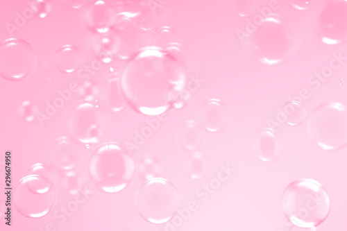 Beautiful soap bubbles floating on pink background