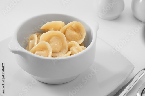close up view of plate with dumplings on white background.