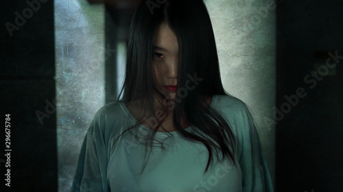 Japanese horror movie style portrait of young strange Asian girl at night in dark solitary hotel corridor looking weird and shady in fear and scary Halloween tribute