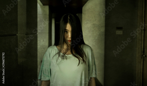 Japanese horror movie style portrait of young strange Asian girl at night in dark solitary hotel corridor looking weird and shady in fear and scary Halloween tribute