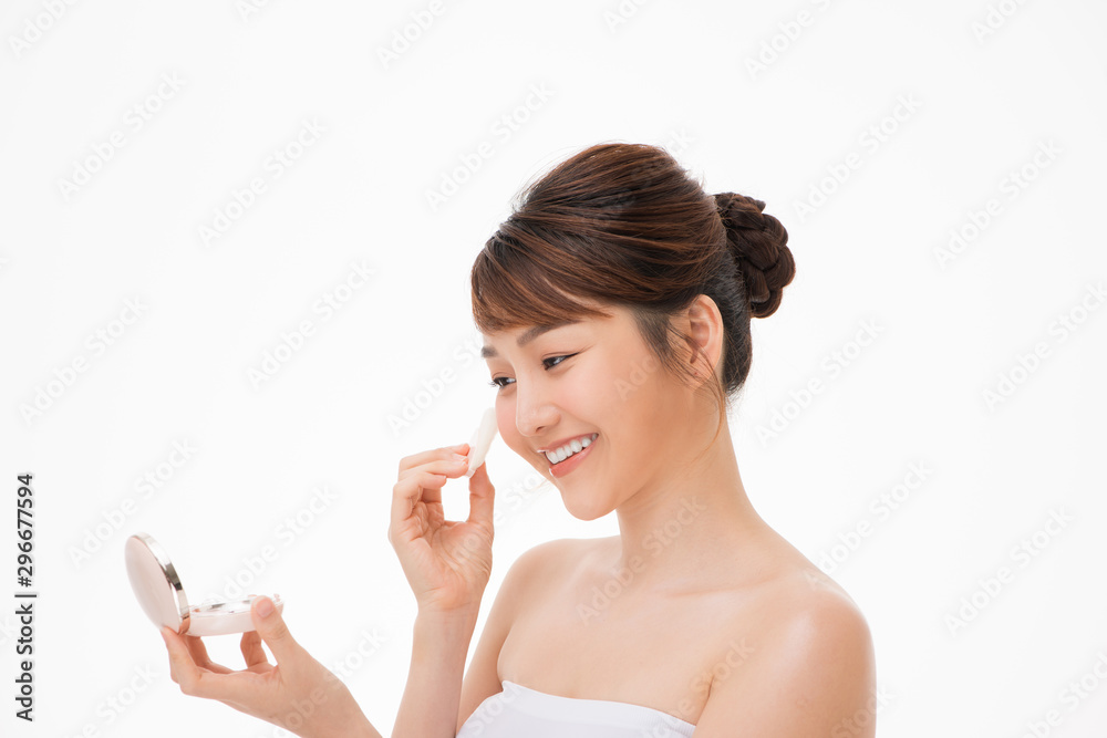 Woman applying cosmetic powder puff on her face Woman applying cosmetic powder puff on her face