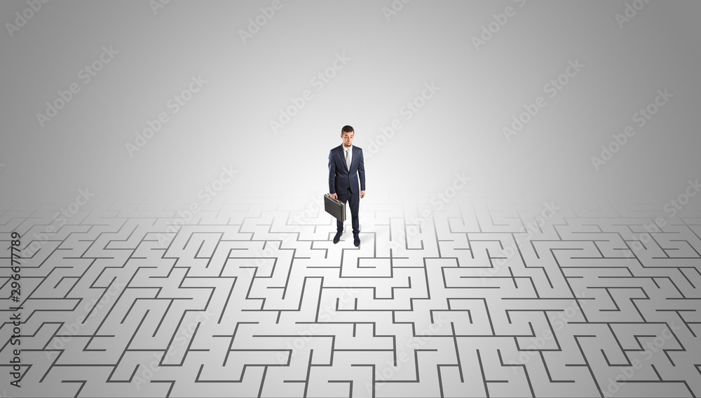 Elegant businessman looking for a solution in a middle of a maze Elegant businessman looking for a solution in a middle of a maze