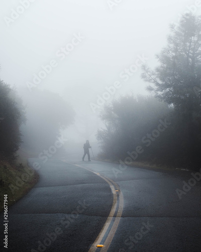 Man hiking through dense cold fog