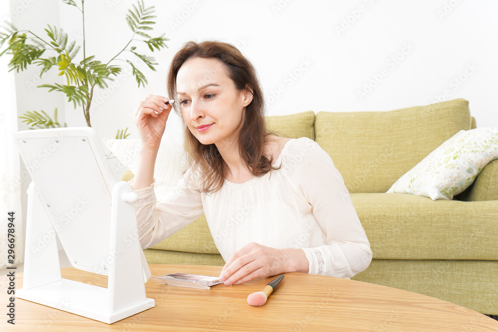 自宅で化粧をする若い女性 自宅で化粧をする若い女性