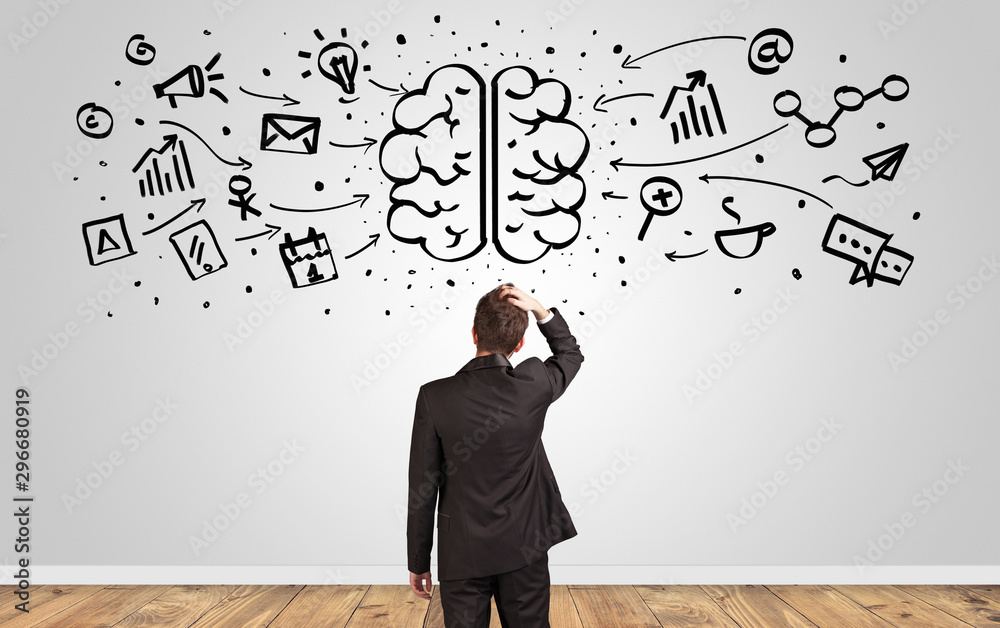 Angry manager looking to wall with drawn overloaded brain concept Angry manager looking to wall with drawn overloaded brain concept