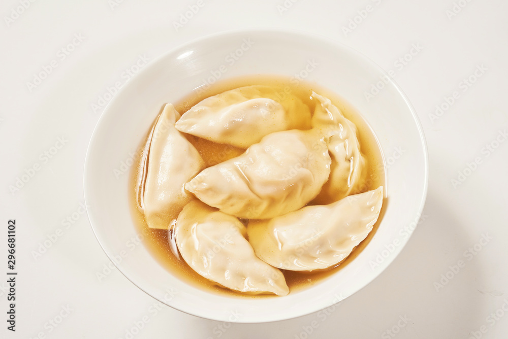 Simple bowl of dumpling soup with white background