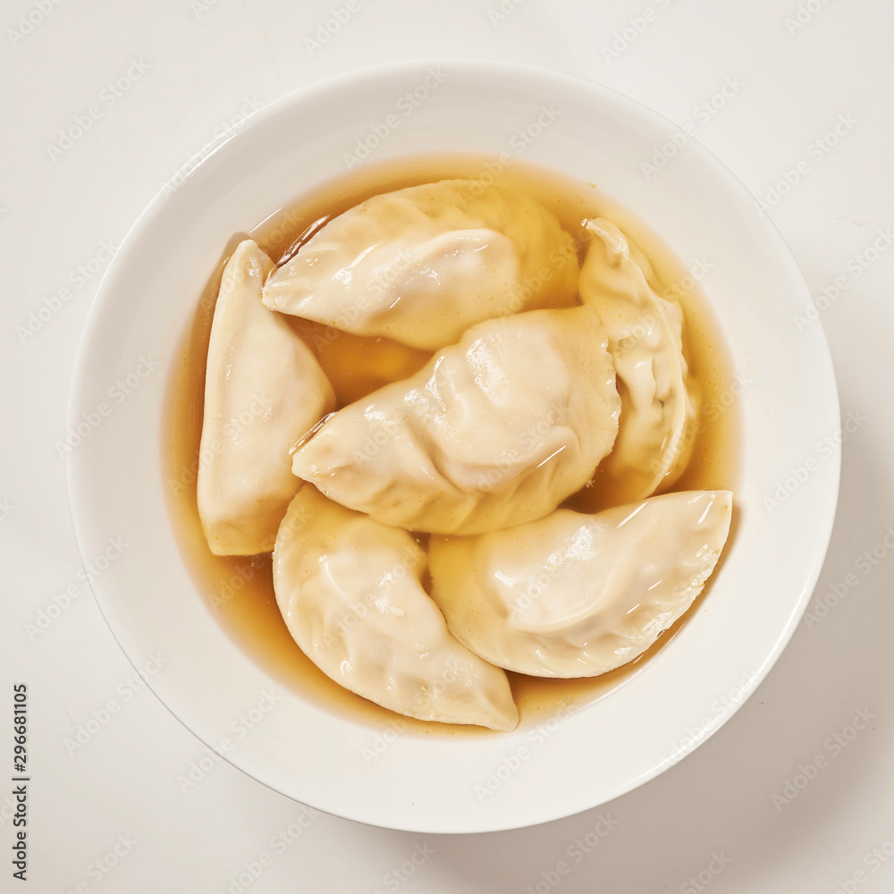 Simple bowl of dumpling soup with white background