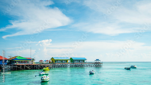 beautiful scenery at Derawan Island. Boats docked in the port with crystal clear water photo