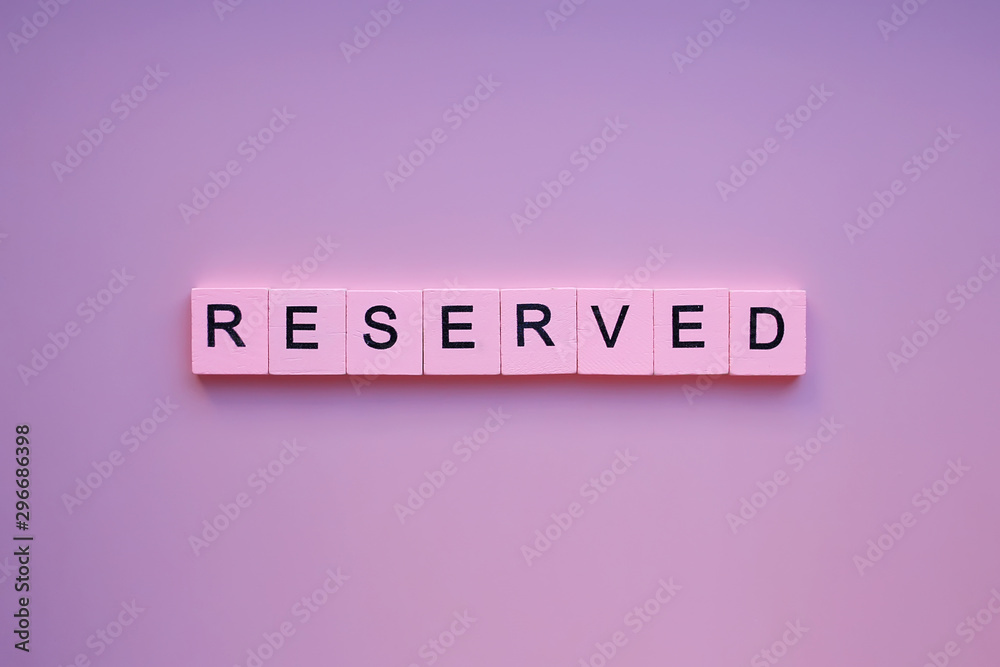 Reserved word wooden cubes on pink background