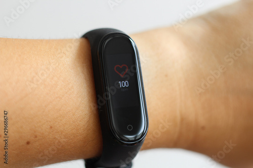 Close-up portrait of sport girl using fitness tracker or heart rate monitor