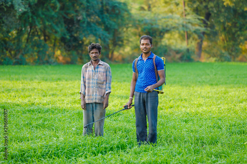 Indian farmer spraying pesticides in green wheat field  © PRASANNAPIX