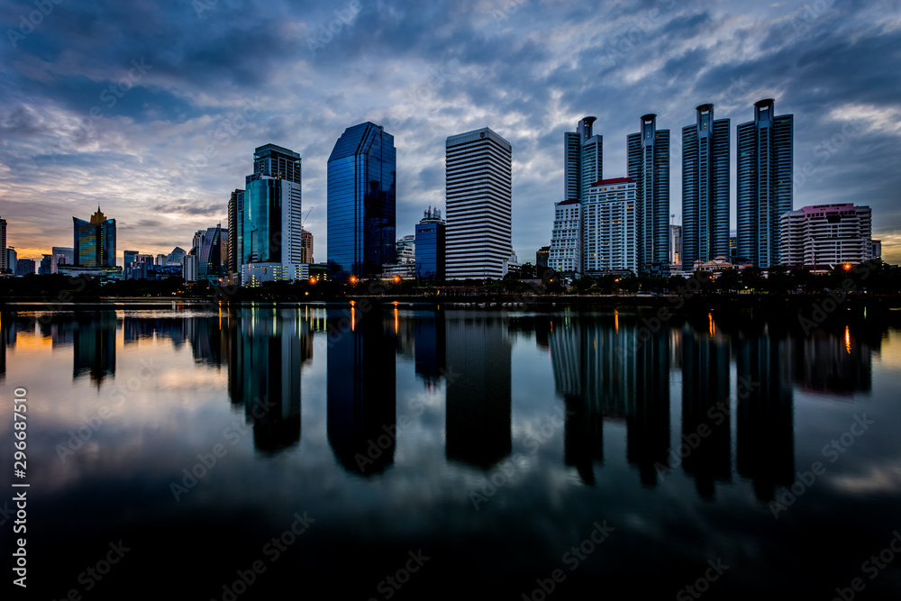 Fototapeta premium Budynek miasta z odbiciem wody przed zachodem słońca