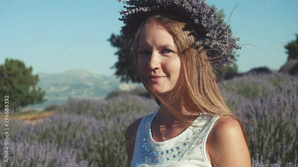 Young woman in lavender wreath standing in lavender field Young woman in lavender wreath standing in lavender field