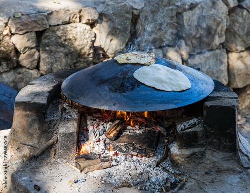 Canvas-taulu Fresh  cakes are fried on a large Bedouin roasting pan for cooking in camping co