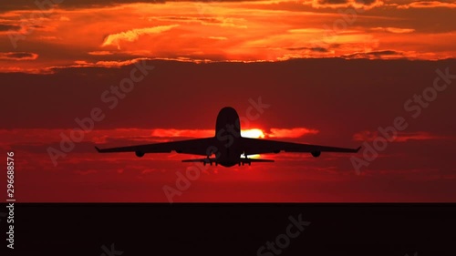 Large passenger airplane taking off and flying towards scenic orange sunset. Suitable as an iillustration for tourism, holidays, vacation, success, business and transportation concept video