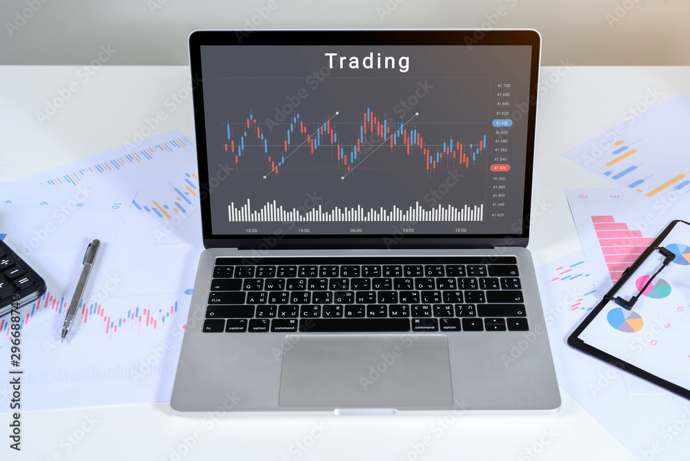 Laptop computer with stock chart market trading on table top. mockup with clipping path for business concept. Laptop computer with stock chart market trading on table top. mockup with clipping path for business concept.