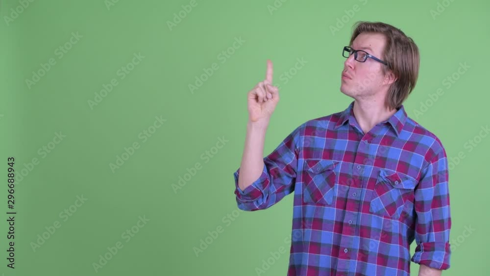 Young handsome hipster man thinking while pointing up Young handsome hipster man thinking while pointing up