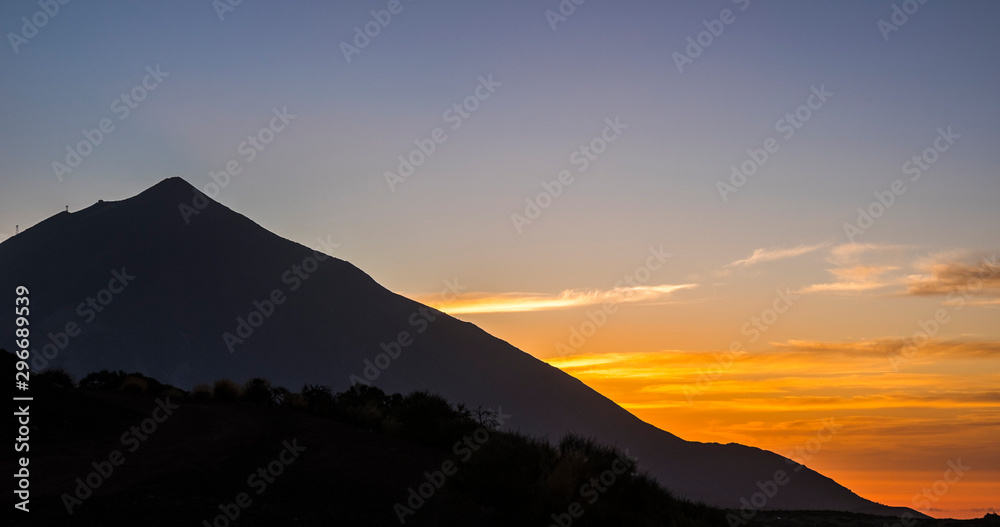 Sunset or sunrise beautiful landscape moment at the mountain - high peak vulcan and coloured sunlight in background - black silhouette - beauty of outdoor nature