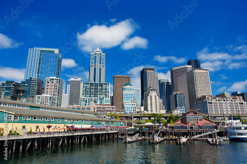 Seattle Ferris wheel, skyline and waterfront sunny day with blue sky and clouds. © KOOKHWAN