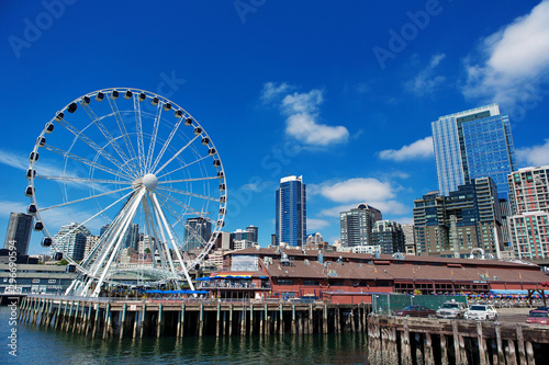 Seattle Ferris wheel, skyline and waterfront sunny day with blue sky and clouds.
