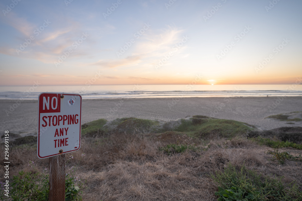 No Stopping Street Sign on the Beach During Sunset. Relaxed Bureaucracy