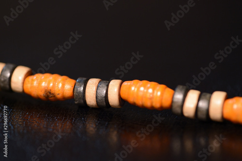 Fragment of a wooden beads necklace on a dark background close up