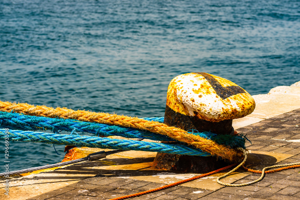 Old mooring bollard with heavy ropes in the port of Gibraltar. Mooring