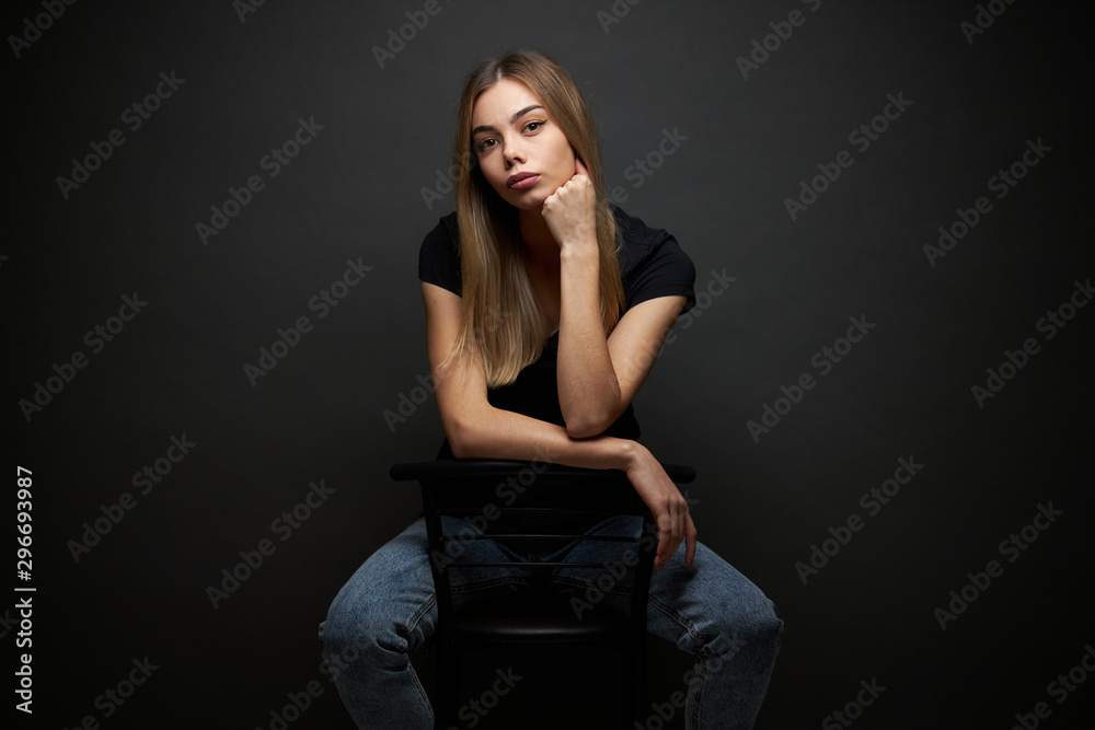 Fashion portrait of a sexy blonde woman with a make up wearing black clothes