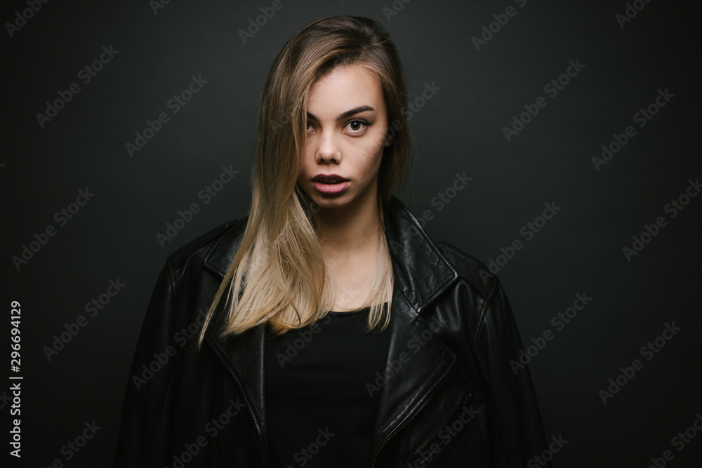 Fashion portrait of a sexy blonde woman with a make up wearing black clothes