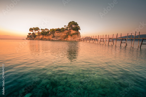 Beautiful sunrise at the famous Cameo island. A beautiful small island with wooden bridge and turquoise water. Zakynthos Greece. In summer.