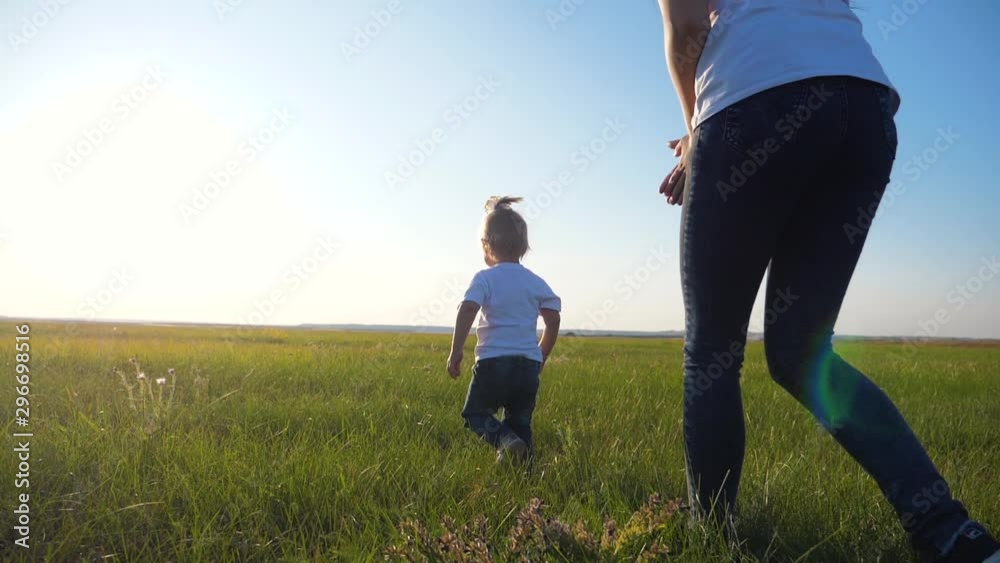 A young mother plays with a child on the street. A woman runs after a little cheerful daughter. Happy family having fun outdoors. A young mother plays with a child on the street. A woman runs after a little cheerful daughter. Happy family having fun outdoors.